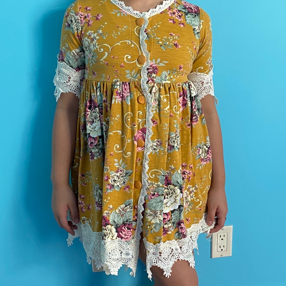 Yellow flower, lace rimmed dress.
